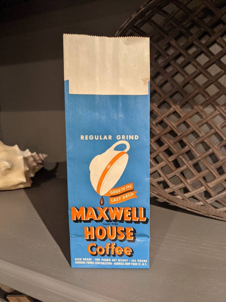 May include: A blue and orange paper bag with the text "Maxwell House Coffee" and the tagline "Good to the Last Drop". The bag is for a one-pound bag of regular grind coffee.