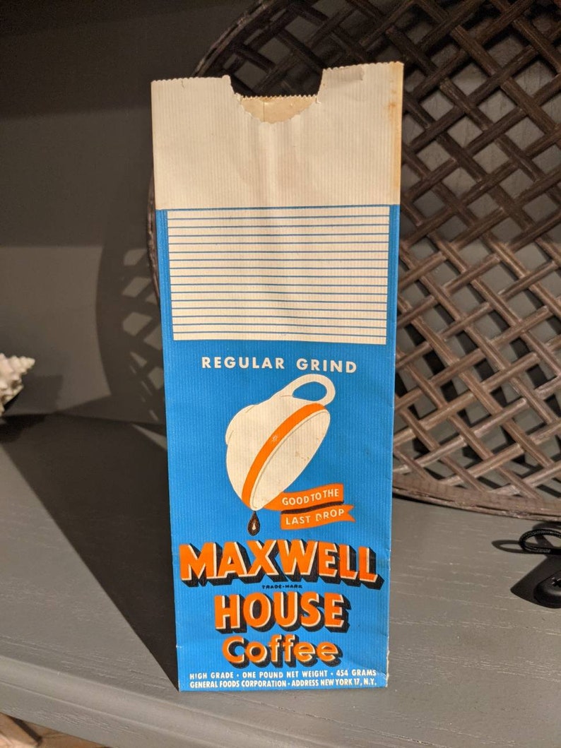 May include: A vintage paper bag for Maxwell House Coffee, featuring a blue background with a white coffee cup and orange trim. The bag reads "Good to the Last Drop" and "Regular Grind". The text also includes "High Grade - One Pound Net Weight - 454 Grams" and "General Foods Corporation - Address New York 17, N.Y."