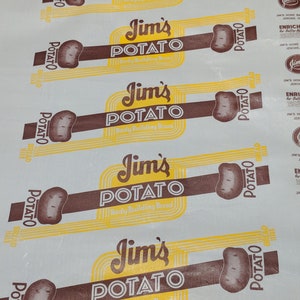 May include: Five white paper bags with a brown and yellow logo that reads "Jim's Potato Body Building Bread". The logo features a brown potato and yellow text.