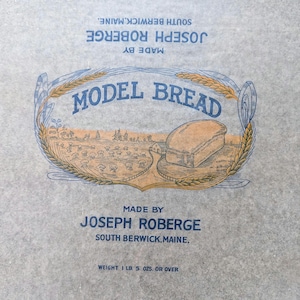May include: Vintage bread wrapper with the text "MODEL BREAD" in blue, surrounded by a wheat and floral design. The wrapper also includes the text "MADE BY JOSEPH ROBERGE, SOUTH BERWICK, MAINE" and the weight, 1 lb. 5 oz. or over.