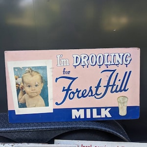 Letrero original de Masonite de la década de 1950 que dice "babeo por la leche de la marca Forest Hill" - Letrero de tienda de campo antiguo y original - Letrero de lechería