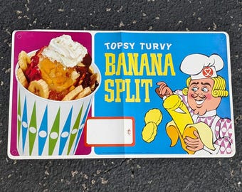Può includere: Un cartello vintage che pubblicizza un "Topsy Turvy Banana Split" con uno chef dei cartoni animati che tiene una banana. Il cartello è rosa, blu e giallo con un'immagine di un banana split con panna montata, salsa al cioccolato e banane a fette.