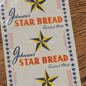 Può includere: Un sacchetto di carta bianco con un motivo ripetuto di una stella blu e gialla con testo rosso e bianco che dice "Johnson's Star Bread Enriched White".