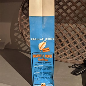 May include: A blue and white paper bag with the text "Maxwell House Coffee" and "Regular Grind" printed on it. The bag also includes instructions for brewing coffee, including proportions and methods.