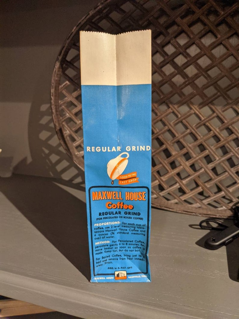 May include: A blue and white paper bag with the text "Maxwell House Coffee" and "Regular Grind" printed on it. The bag also includes instructions for brewing coffee, including proportions and methods.