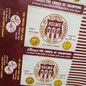 Puede incluir: Un anuncio vintage para el pan Helms, con un logotipo rojo y blanco con el texto "Elección de los campeones olímpicos" y "Helms Bread". El anuncio también incluye el texto "El pan que voló alrededor del mundo" y "Siempre la elección de los campeones".