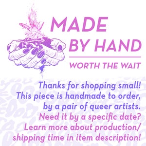May include: A pink and purple illustration of two hands holding a flame. The text "MADE BY HAND WORTH THE WAIT" is below the illustration. The text "Thanks for shopping small! This piece is handmade to order, by a pair of queer artists. Need it by a specific date? Learn more about production/shipping time in item description!" is below the text.