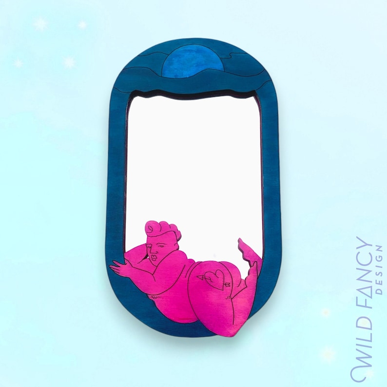 Puede incluir: Un espejo ovalado de color azul verdoso con una figura rosa de una persona asom&aacute;ndose por detr&aacute;s del marco. La figura est&aacute; en una pose reclinada con el brazo apoyado en el marco. La parte superior del espejo tiene un dise&ntilde;o de luna azul y olas.