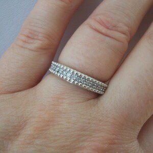 May include: A silver ring with a double row of small, clear stones.