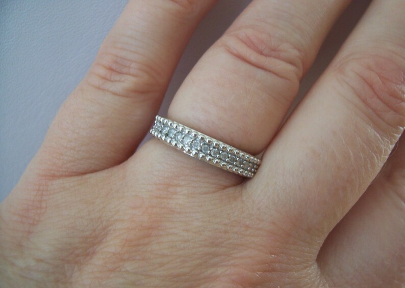 May include: A silver ring with a double row of small, clear stones.