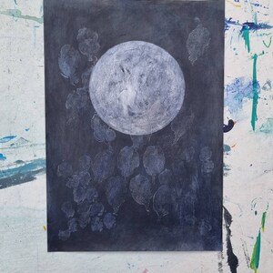 May include: A white circle on a dark gray background with white shapes surrounding it. The circle has a textured surface.
