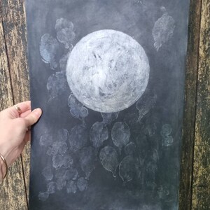 May include: A black and white moon print with white leaf shapes on a dark background.
