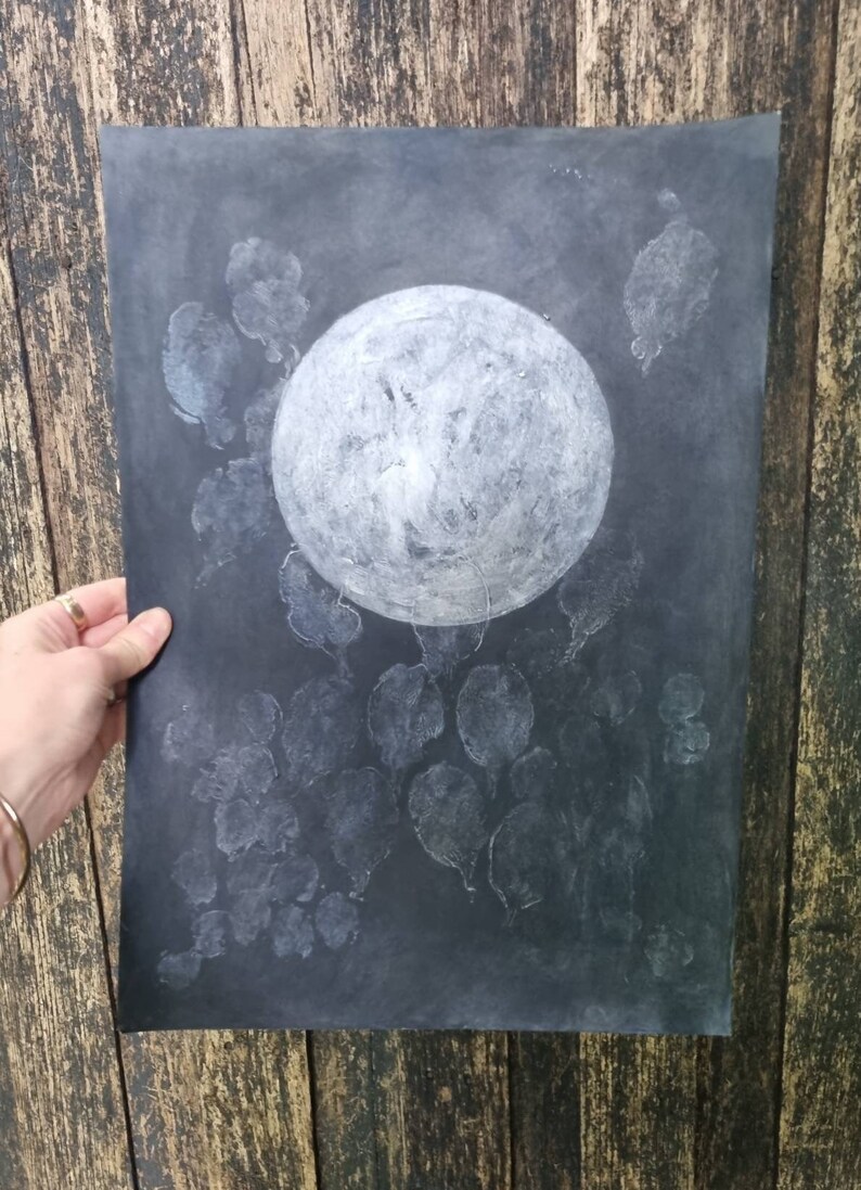 May include: A black and white moon print with white leaf shapes on a dark background.