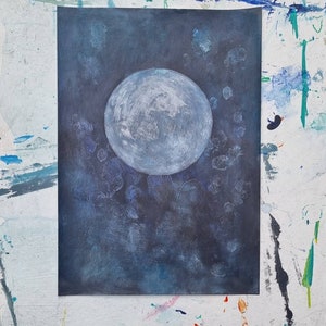 May include: A painting of a large, white moon on a dark blue background with white speckles. The moon is in the center of the painting and is the main focus.