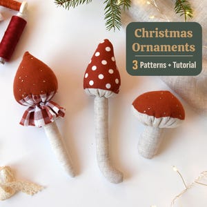 May include: Three handmade mushroom Christmas ornaments. The ornaments have red caps with white polka dots and beige stems. One mushroom has a red and white checkered skirt. The image includes the text "Christmas Ornaments 3 Patterns + Tutorial."