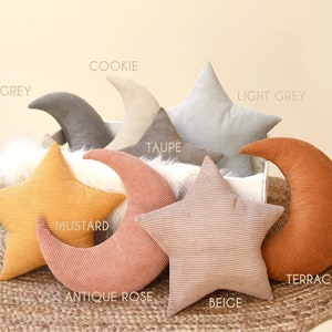 Op de afbeelding: Een set van acht decoratieve kussens in verschillende kleuren en patronen. De kussens zijn gevormd als sterren en halve manen. De kleuren omvatten grijs, lichtgrijs, taupe, cookie, mosterd, antiekroze, beige en terracotta.