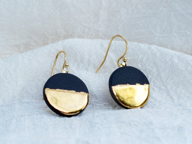 Black and gold ceramic earrings. Porcelain disc and gold plated surgical steel ear hooks. Minimalist earrings handmade in France. image 1