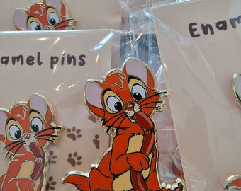 May include: Three enamel pins featuring a cartoon orange cat holding a sausage. The pins are on a white background with brown paw prints. The text "Enamel Pins" and "mademo.pins" are visible on the cards.