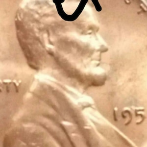 May include: A copper-colored US penny with the words "God We Trust" and "Liberty" visible. The year 1995 is printed on the coin. The profile of Abraham Lincoln is visible on the coin.