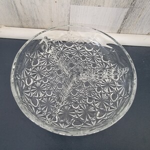 May include: A clear glass divided serving dish with a starburst pattern. The dish has three sections and is perfect for serving snacks or appetizers.