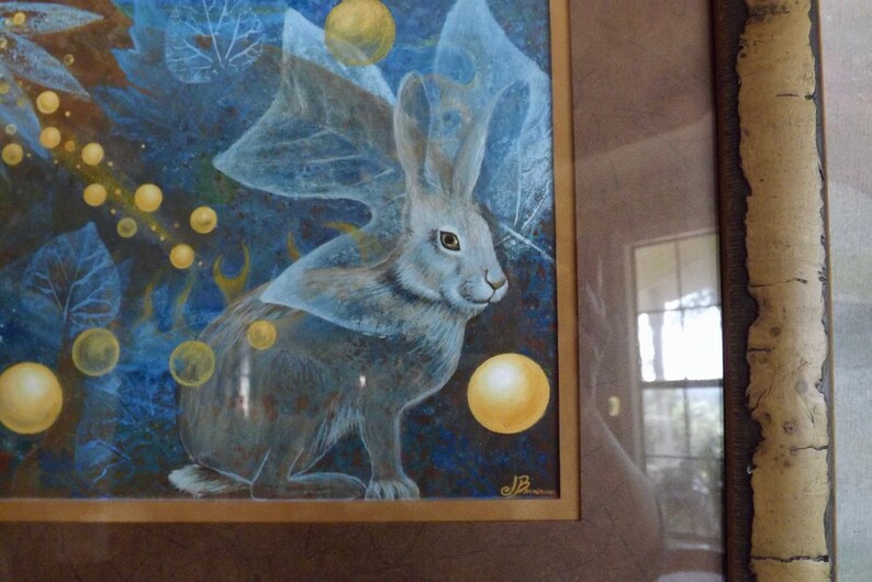 May include: A painting of a white rabbit with a blue and white patterned wing, surrounded by yellow and white orbs on a blue background.