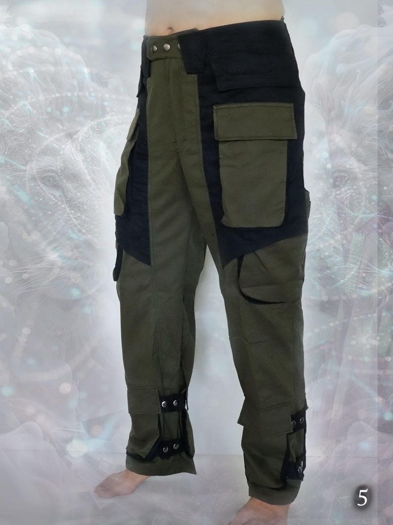 May include: Green cargo pants with black accents and adjustable straps at the ankles. The pants have multiple pockets and a belt loop.