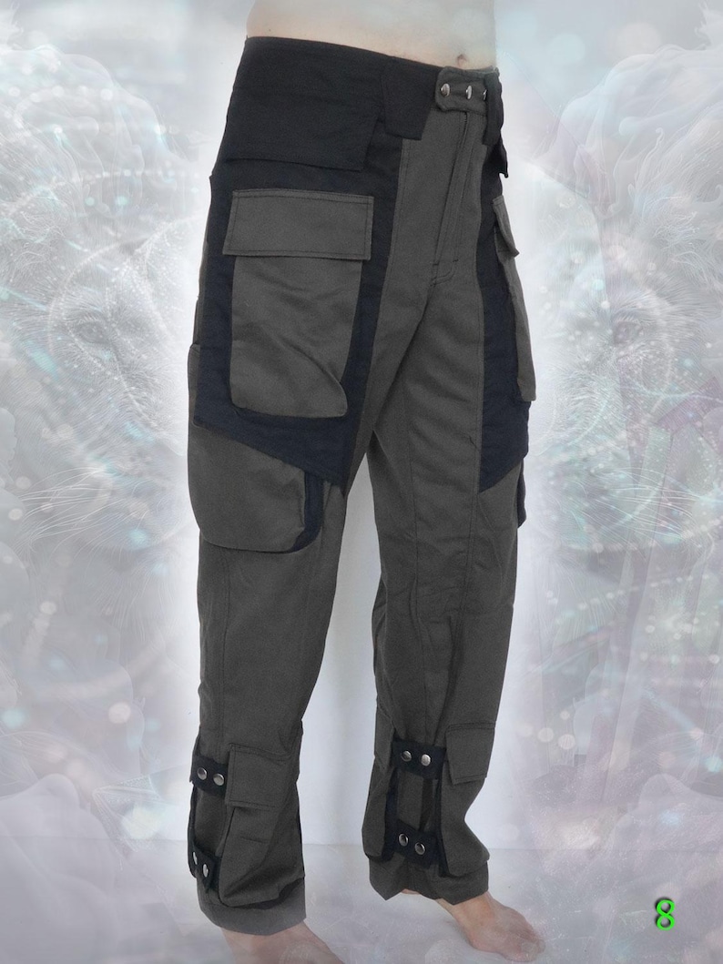 May include: Dark green cargo pants with black accents and multiple pockets. The pants have adjustable straps at the bottom of the legs.