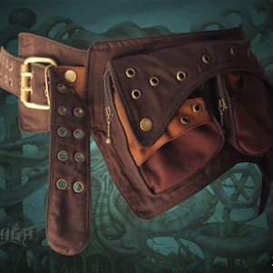 May include: A brown leather belt with multiple pockets and a buckle. The belt has a brown canvas strap with metal rivets and a zippered pocket.