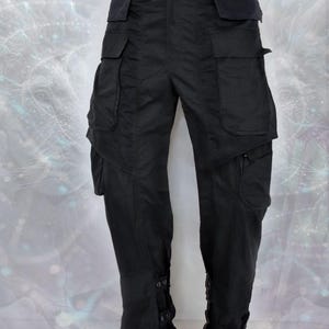 May include: Black cargo pants with multiple pockets and adjustable straps at the bottom of the legs.