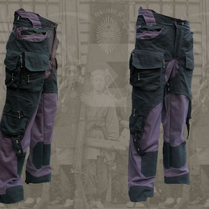 Pu&ograve; includere: Pantaloni cargo viola e neri con pi&ugrave; tasche e cinturini. I pantaloni hanno un design unico con un aspetto a strati.