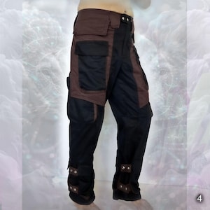 Black cargo pants with brown accents and multiple pockets. The pants have adjustable straps at the bottom of the legs.