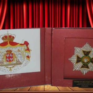 May include: A red, white, and blue coat of arms with a crown on top. The coat of arms is surrounded by a gold frame. The image is on the left side of a red box. The right side of the box has a silver and gold star-shaped medal with a red, white, and blue ribbon. The medal is surrounded by a gold frame. The text "Order of Military Virtue" is printed on the box.