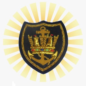 May include: A gold embroidered patch with a navy blue background. The patch features a gold anchor with a crown on top and a chain attached to the anchor. The patch is surrounded by a yellow sunburst.