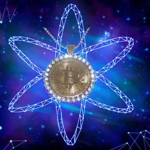 May include: A gold-colored pendant necklace with a large, round, bitcoin-shaped charm. The charm is surrounded by a ring of small, clear stones. The necklace is hanging against a blue and purple background with a white, star-shaped design.