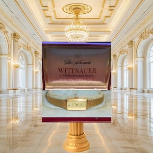 May include: A gold-tone Wittnauer The Silhouette watch with a rectangular face and a textured metal link bracelet, presented inside a dark red display box with the brand name and A Longines-Wittnauer Product printed in gold lettering on the interior.