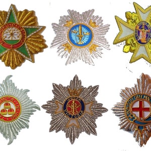 May include: Six embroidered star-shaped badges with different designs and colors. The badges feature various symbols, including crowns, crosses, and swords. The badges are likely for ceremonial or official use.
