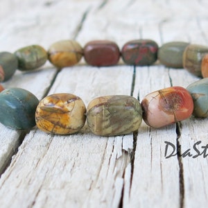 May include: A bracelet made of colorful, multi-colored, and patterned stones. The bracelet is made of natural stones and has a rustic look.