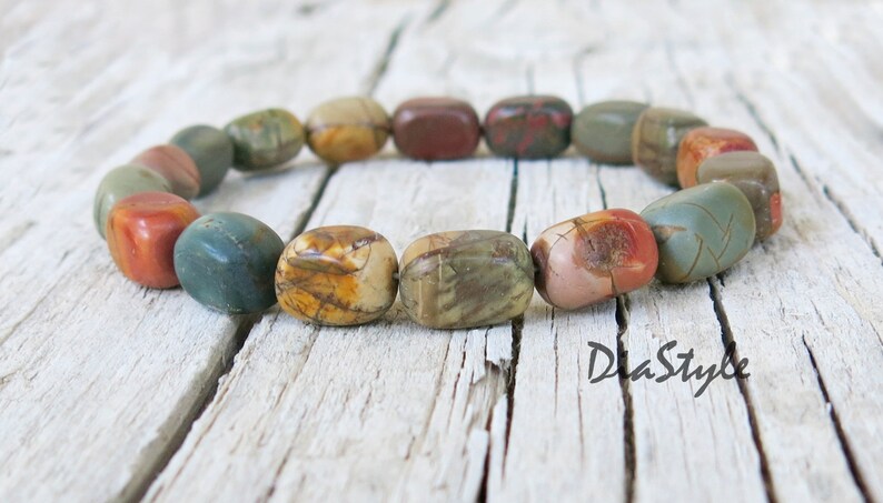 May include: A bracelet made of colorful, multi-colored, and patterned stones. The bracelet is made of natural stones and has a rustic look.