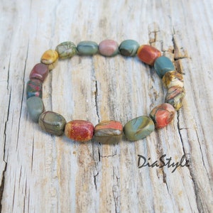 May include: A bracelet made of colorful, oval-shaped stones. The stones are a mix of brown, red, green, and white.