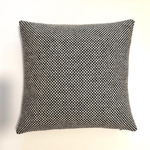 May include: Black and white checkered throw pillow with a square pattern.