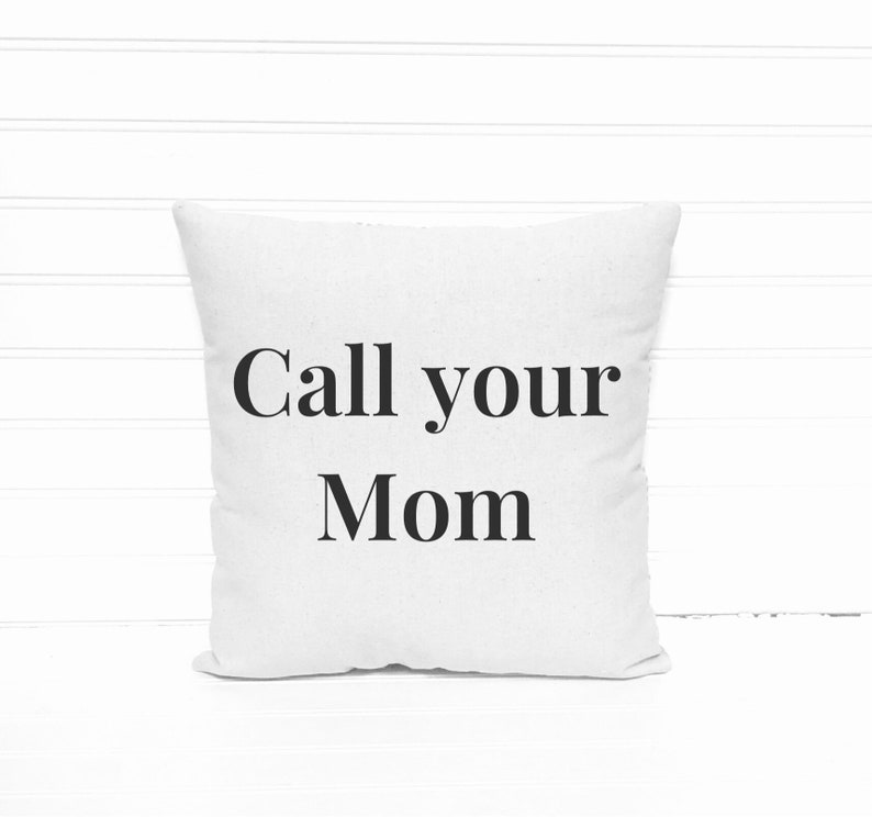 May include: Square white throw pillow with the text "Call your Mom" in black, centered on the front. The pillow is made of a soft, textured fabric and is displayed against a white background.