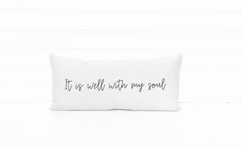 May include: White rectangular pillow with the handwritten text "It is well with my soul" in black script. The pillow is on a white surface with a white background.