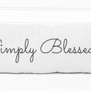 May include: White rectangular pillow with the text "Simply Blessed" in black cursive script.