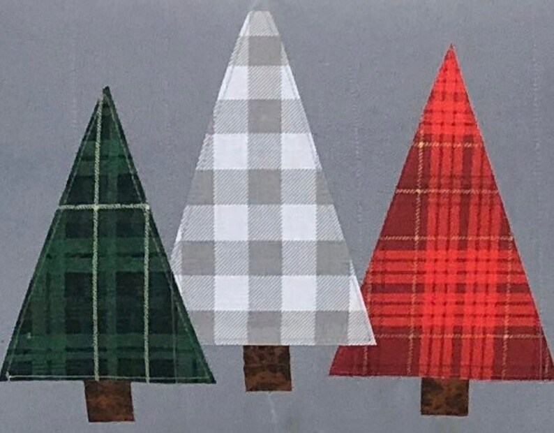 May include: Three fabric Christmas trees in a row. The tree on the left is green with a plaid pattern. The middle tree is white and gray with a gingham pattern. The tree on the right is red with a plaid pattern.