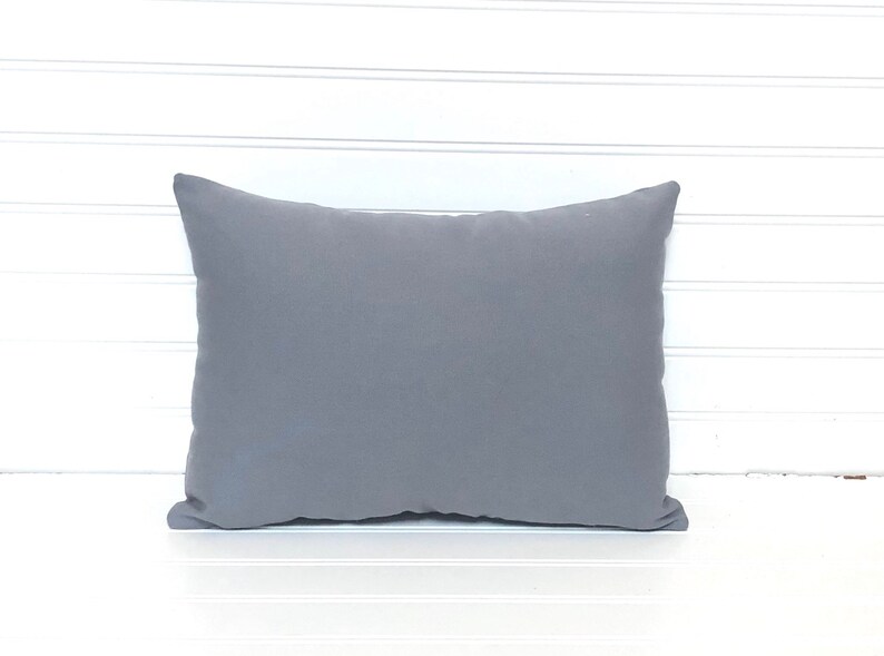 May include: A plain gray throw pillow with a soft, slightly textured fabric.