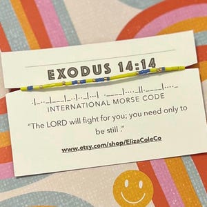 May include: A white card with the text "EXODUS 14:14" and "INTERNATIONAL MORSE CODE" printed on it. The card also includes the quote "The LORD will fight for you; you need only to be still." and the website address "www.etsy.com/shop/ElizaColeCo".