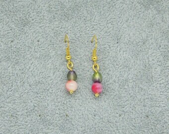 May include: A pair of gold dangle earrings with three beads each. The beads are pink, green, and purple.