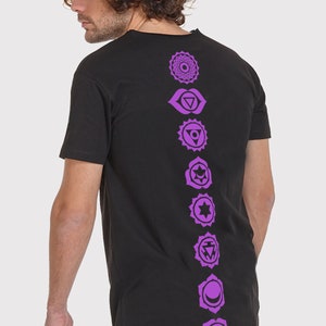 Pode incluir: Camiseta preta de manga comprida com uma fileira vertical de sete s&iacute;mbolos de chakras roxos impressos nas costas.