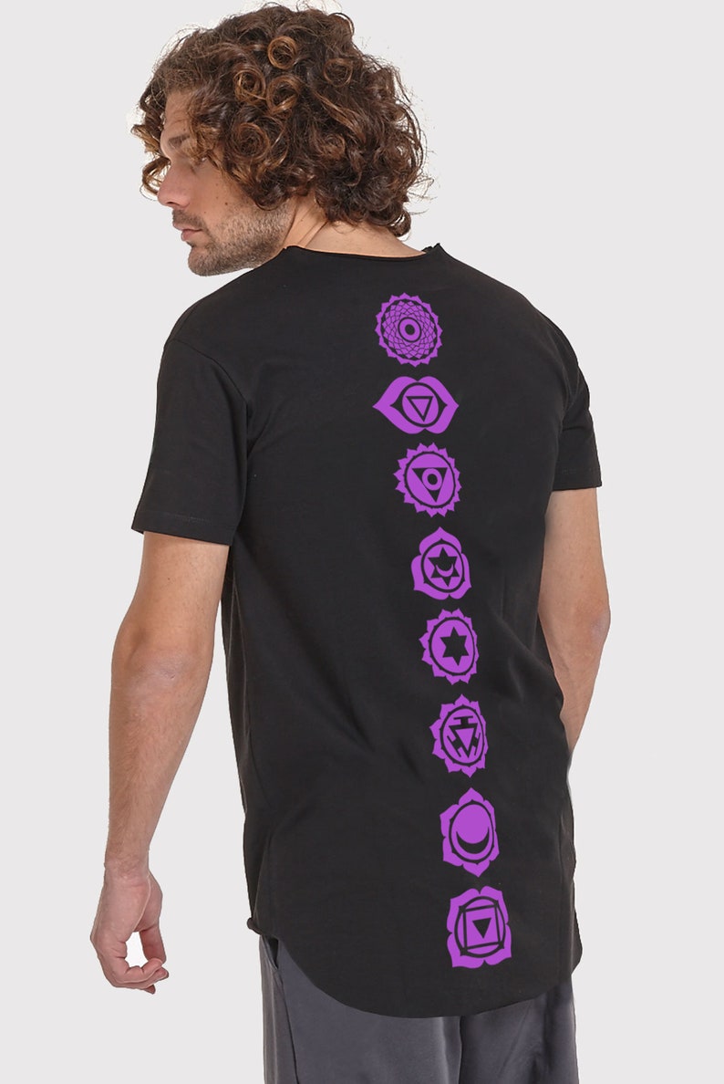Pode incluir: Camiseta preta de manga comprida com uma fileira vertical de sete s&iacute;mbolos de chakras roxos impressos nas costas.