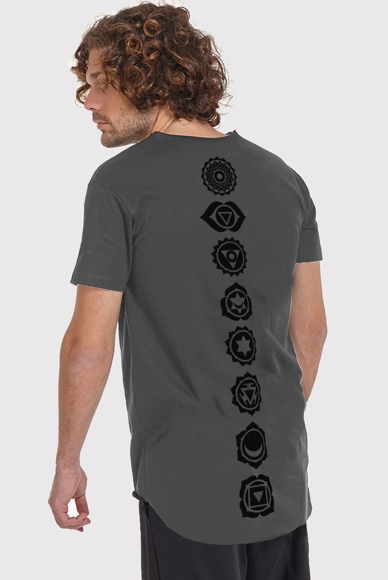 Pode incluir: Uma camiseta cinza-chumbo com uma fileira vertical de sete s&iacute;mbolos de chakras pretos impressos nas costas.